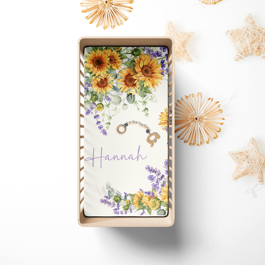 Fitted personalized crib sheet in a wooden crib featuring featuring a delightful bouquet pattern inspired by the cheerful beauty of sunflower blossoms.