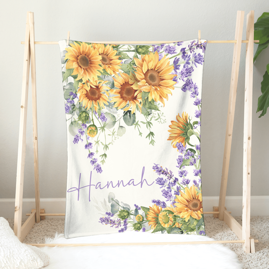 Personalized minky plush blanket hanging on a wooden hanger featuring a delightful bouquet pattern inspired by the cheerful beauty of sunflower blossoms.